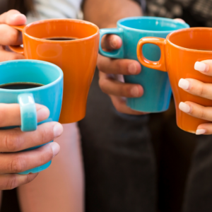 4 pairs of hands holding coffee cups